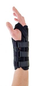 close up of person wearing supportive black brace on wrist secured with velcro straps